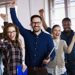 four people with arms raised in the air